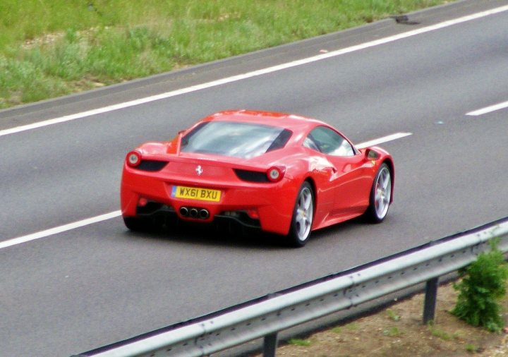 A red car is parked on the side of the road - Pistonheads