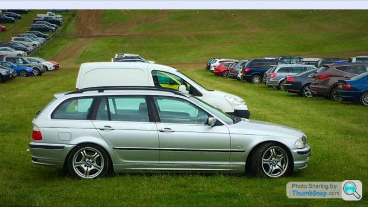 Bmw E46 Touring for £350?! - Page 3 - Readers' Cars - PistonHeads - The image showcases an open, grassy lot inhabited by an array of cars and trucks, all parked neatly in rows. The environment gives off a vibe of a day out, possibly at a picnic area or a flea market. The vehicles, varying in color and model, are also diverse in size, indicating a wide variety of attendees. The grass underfoot and the open sky above suggest a sunny day, with no sign of rain or stormy conditions.