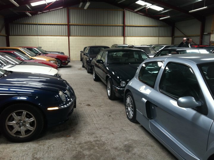 A car parked next to a parking meter - Pistonheads - The image shows an indoor garage or storage area with a variety of vehicles. There are six cars of different models and colors, ranging from compact to larger vehicles. Some of the cars are parked side by side, while others are single-car spots. The floor appears to be concrete, and the cars' reflections suggest proper lighting. The setting seems to be used for storing vehicles, possibly in a commercial environment.