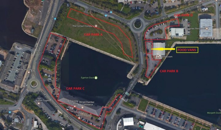 Cars & Coffee Wirral Sunday 11th February - Page 1 - North West - PistonHeads - The image is an aerial view of a large, redacted area, with various rectangular parcels of land outlined in red. The parcels appear to contain buildings, roadways, and other infrastructure. Some of the parcels are labeled with names like "Foood Park," "Aqua Park," and "Cross Park." The redacted areas are interspersed with green spaces, and a large body of water is visible, surrounded by either buildings or parcels of land. The layout suggests a planned or designed urban or mixed-use development.