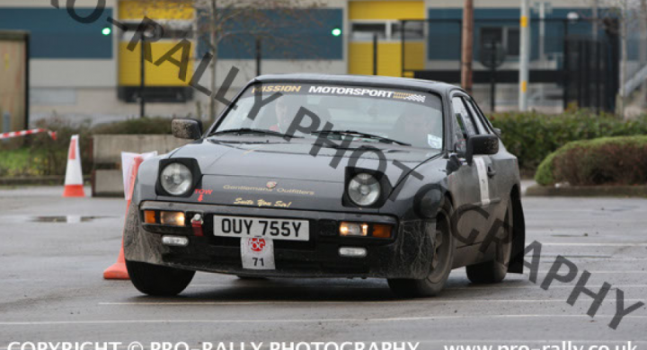 A car that is sitting in the street - Pistonheads - This image showcases the front of a black rally car with an orange cone partially obscuring its fender. The car appears to be resting on a paved surface during daylight. The registration plate, OWY 755Y, is visible along with the car's lights. A building is partially visible in the background, suggesting an urban setting. A watermark text "Copyright @ PRO-RALLY-PHOTOGRAPHY wwww.pro-rally-uk" is overlaid on the image, indicating ownership and documentation.