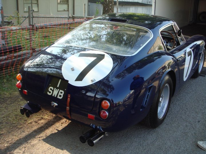 - Page 277 - Supercar General - PistonHeads - The image captures a serene garage scene with a striking blue race car as the centerpiece. The car, bearing the number 7 and the "SWB" logo, is parked inside the garage, with its polished body gleaming under the ambient light. In addition to the car, there's a person visible, possibly the owner or someone involved in the car's upkeep. The background hints at the presence of a residential building, adding a touch of everyday life to the otherwise automobile-dominated scene.