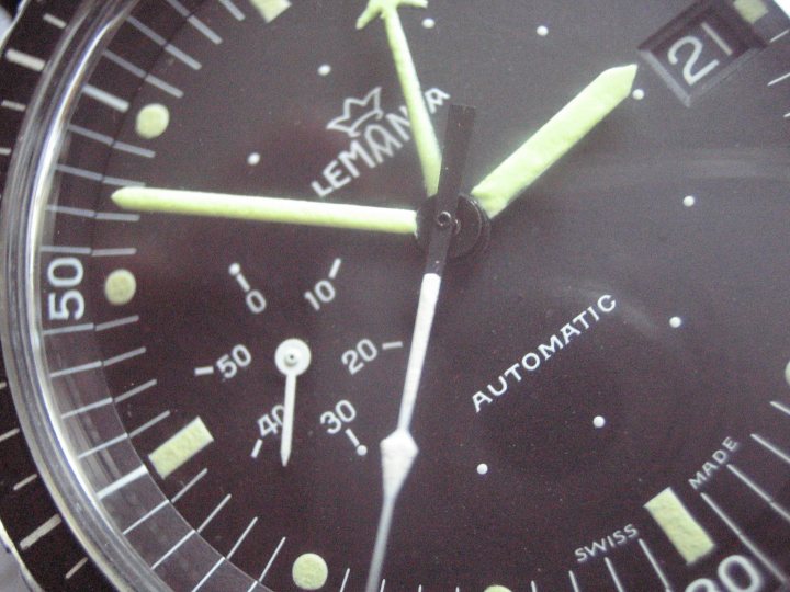 Pistonheads Issue Lemania African Air Force South - The image presents a close-up view of a watch face. The watch appears to be of a brand that reads "LePost." Its face is black with white numerals at 12, 3, 6, and 9 o'clock positions. Green watch hands are visible against the black background, indicating the time as approximately 2 o'clock. The watch's name is also visible, showing it's a LePost watch.