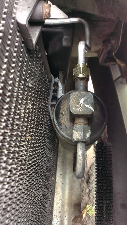 A black and white photo of a blender - Pistonheads - The image shows an outdoor setting focusing on a close-up view of a metal surface and a hardware component. There's a bolt attached to a rack that features a circular gear-like element. The metal surface has a grid-like texture, giving it a somewhat rugged appearance. The background is blurred, likely due to a shallow depth of field, which emphasizes the objects in the foreground. The overall composition suggests that this photo might have been taken in the context of a project or a repair work involving the metal rack and the gear-like component.