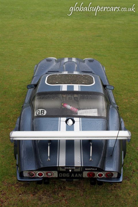 Sunday April 25th Bradford on Avon - Marocs - Page 1 - South West - PistonHeads - This image features a vintage racing car, which is of a blue and dark blue color scheme with white stripes, on a grassy surface. The car's license plate is visible, and it's equipped with additional rear customs lights. The car appears to have a high-performance status, possibly due to its racing history. The image also contains text that says "global supercars.co.uk," which suggests that this could be the source of the vehicle or a related website.