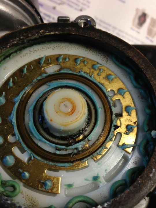 A fire hydrant that has been made to look like a face - Pistonheads - This image provides a close-up view of the inner surface of a clock face. The central feature is a large, white circular motif, possibly representing the face of a clock with black hands. Surrounding this motif is a vibrant array of different shades of blue, green, and gold, which likely represent the numbers on the clock or some form of artistic representation. This could also be interpreted as a close-up of a diamond cut gem stone possibly measuring up to two feet in diameter from an overhead, top down view.