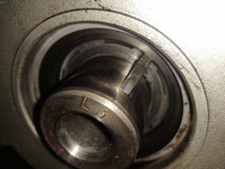 Pistonheads - The image shows a close-up view of a metallic object with a hole in the center. There are two screws visible, one at the top and another at the bottom of the hole. The background is out of focus, emphasizing the subject in the foreground. It appears to be a mechanical or industrial setting due to the presence of metal parts and machinery.