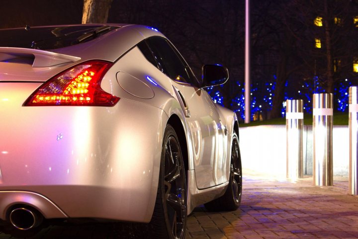 Photos Session In London - Page 1 - Photography & Video - PistonHeads - This image captures a silver car parked in a lot at night. The car is oriented towards the right side of the frame, with the rear left corner more visible due to a side angle view. The car is parked at a parking meter that shows no outstanding time remaining. The setting appears to be in an urban environment, with the reflections of the car and the pole in the wet surface that's likely from recent rain.