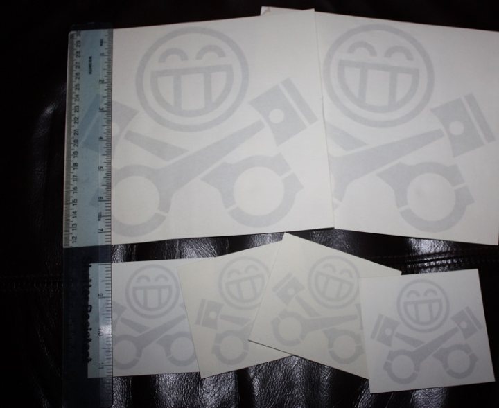 A close up of a pair of scissors - Pistonheads - The image shows a collection of five smiley face stencils on clear tape samples. Each stencil features a different size of a smiling face, and below them are three smiley face emojis that seem to be tied together by a string. The background is dark, and the tape samples cast a slight shadow on it. The overall setup suggests a presentation or display for these stencils or emojis.