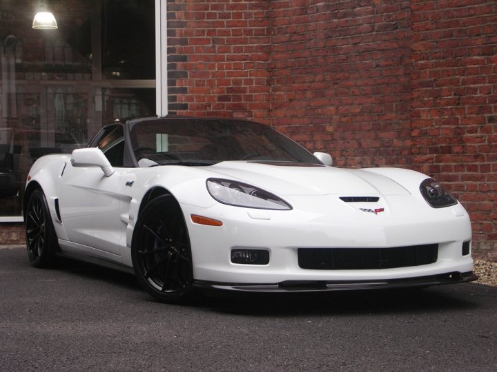 How about some ZR-1 photos to cheer you up? - Page 1 - Corvettes - PistonHeads - The image showcases a sleek, white sports car parked against a red brick wall. The car is positioned at a slight angle, highlighting its long hood and short rear deck. The presence of a Lamborghini logo on the front is distinctive, indicating the brand of the vehicle. The overall setting is quiet and serene, as there are no visible people or other vehicles. The focus of the image is clearly on the sports car and its design.