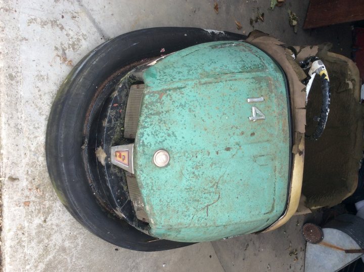 Tri-ang pedal car restoration - Page 5 - Homes, Gardens and DIY - PistonHeads - The image displays a discarded, partially disassembled rusted turquoise object with a number '14' on its side. It appears to be an appliance lacking its back cover. It's outdoors on a concrete surface, with rust stains visible on certain parts.