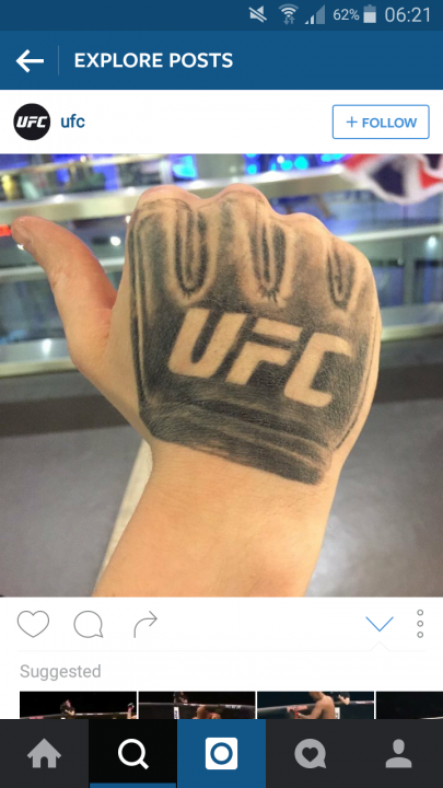 The MMA thread - Page 229 - Sports - PistonHeads - The image displays an Instagram post featuring a close-up of a person's arm, which is prominently adorned with a tattoo of the UFC logo. The tattoo covers a substantial portion of the arm, extending from the wrist to just above the elbow. The UFC logo, which is a black and white graphic depicting two stylized fists, is the central motif of the tattoo. The person's arm is positioned at an angle where the tattoo appears to be three-dimensional and detailed. In the background, there are indistinct patterns and lights that do not take away from the focus of the image, which is the tattoo.