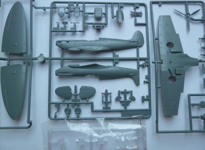 Tamiya 1:72 Spitfire Mk1 + Details - Page 1 - Scale Models - PistonHeads - The image presents a collection of grey plastic parts that appear to be designed for an intricate model-making project. These parts are arranged neatly on a white, patterned background. The models seem to include a fighter jet and a submarine, as indicated by the shapes of the individual components. The precision of the parts suggests a high level of detail will be required for assembly, possibly a build that is both tactile and educational.