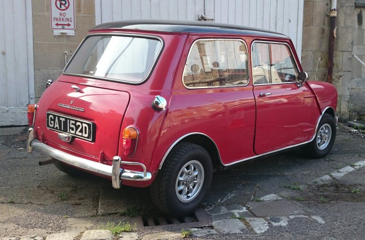 COOL CLASSIC CAR SPOTTERS POST!!! Vol 2 - Page 67 - Classic Cars and Yesterday's Heroes - PistonHeads - The image depicts a charming scene of a red, miniature car parked on a street. The car boasts larger black tires that contrast beautifully with its vibrant red color. It's parked next to a rustic brick wall and is near a white garage door, adding a touch of quaintness to the setting. A no parking sign hangs on the wall behind the car, adding a dash of humor to the image. The car's compact size and its vivid color make it the focal point of this street corner scene. The brick wall and white garage door in the background provide a contrast to the bright red car, complementing the overall composition of the image.