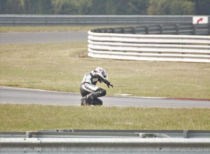 the bb trackday thread.   - Page 430 - Biker Banter - PistonHeads - The image shows a person riding a motorcycle on a grassy area. The rider appears to be moving at high speed, with the front wheel lifted off the ground, indicating acceleration. The rider is wearing a full-face helmet with a visor and what appears to be a leather or high-performance riding suit.

The surrounding fence, with its energetic zigzag design, suggests the rider may be passing a boundary or track limit, often found at racing circuits. The ground is lush and green, contrasting with the angular and industrial metal barriers.

The focus and intensity of the moment, along with the dynamic setting, evoke a sense of motion and exhilaration, typical of high-speed motorcycle racing. The high-resolution quality of the image allows for the details of the rider's gear and the environment.