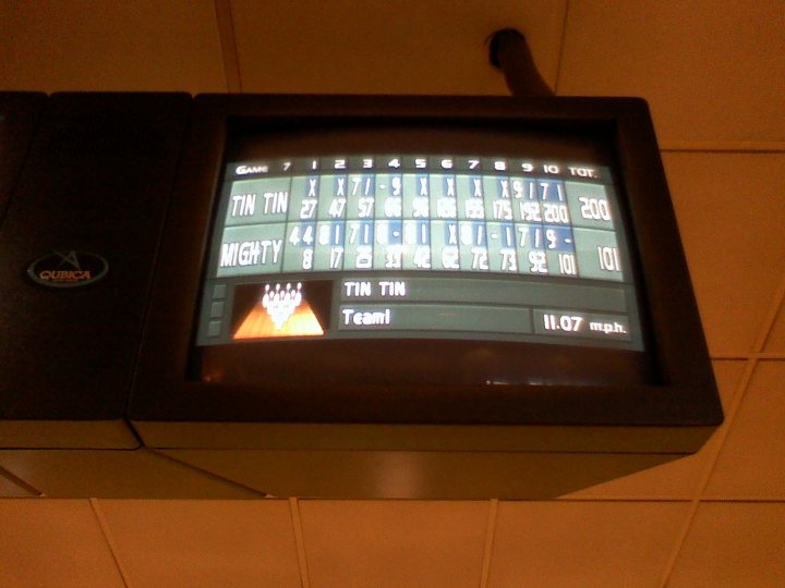 Pistonheads - This image captures a TV screen during a bowling game. The screen displays a score for what appears to be a "Team event," with "TWIN TIN" as the opposing team. The scores of the bowling game are listed, indicating that one lane has been knocked down but one has not. The bowler's score reads "Team 11.07 mph." There's also a striking company logo visible on the screen, suggesting that the bowling alley or lane might be associated with that company.