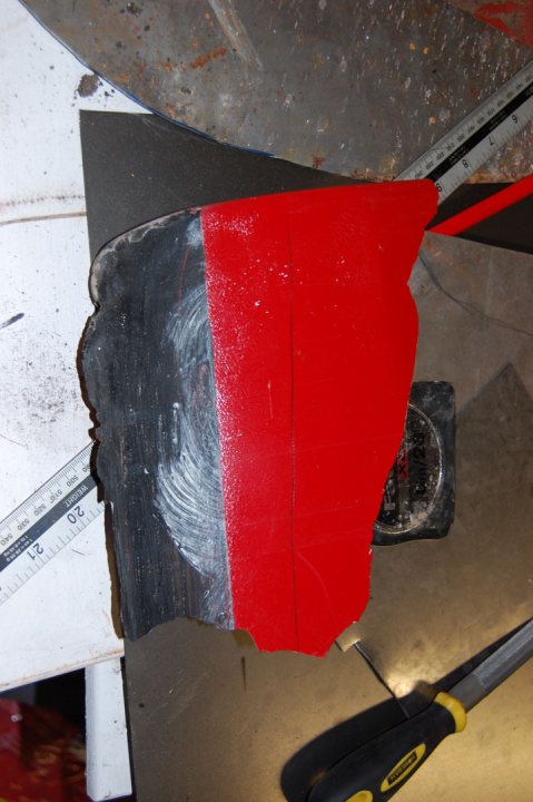 Pistonheads - The image shows a workshop scene with a focus on a red power tool. The tool appears to be a roulette cutter, a size measuring tool in the background, a pair of scissors on the right, and a sheet of metal with various objects scattered on it, essential to a workshop. The tool is lying on a wooden surface, suggesting that it may have been recently used or is about to be used.