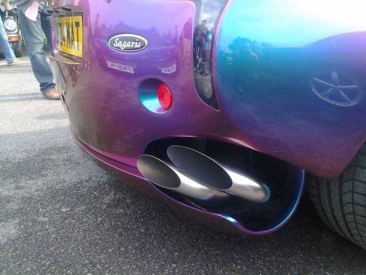 Supercar Sunday Pistonheads - The photo showcases a striking purple car front, with its hood open. The car exudes an aura of luxury with its shiny chrome and sleek design. A blazing red light on the right side of the grill adds a touch of attention-grabbing appeal. Under the hood, two silver tailpipes are visible, indicating the powerful engine behind this elegant exterior. The car seems to be parked or stationary, ready to roar into life or just cool off. The overall scene suggests a scene of either showcasing or preparing the car for a drive.