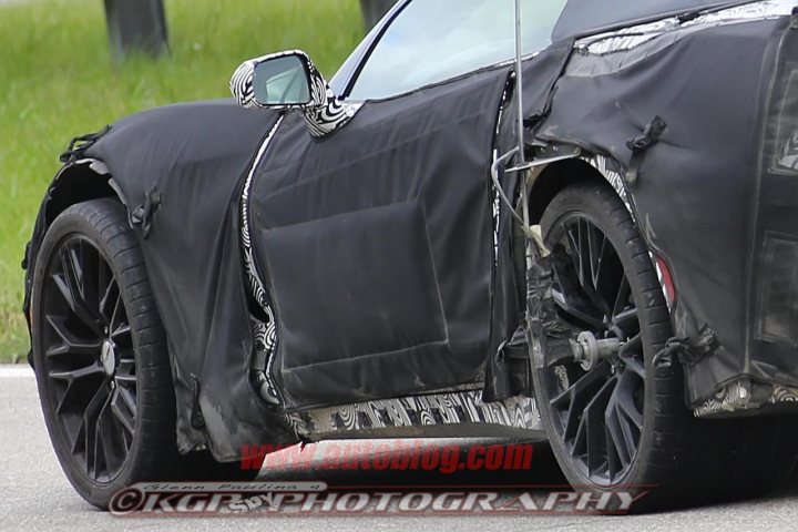 C7 Z0? Mule - Page 1 - Corvettes - PistonHeads - The image features the side profile of a vehicle, which appears to be a car. The car has a distinctive black fabric that has been partially applied over the tire and padding on the wheel well, just behind the tire. This type of application is likely for stylistic and/or protective purposes. The car's bodywork also seems to be missing or being covered by another material, perhaps in a repair setting, as suggested by the presence of various mechanical parts in the background. The fact that the image is copyrighted and likely belongs to a specific photography company suggests that this photo might have been taken during a commercial shoot related to automotive design or aftermarket accessories.