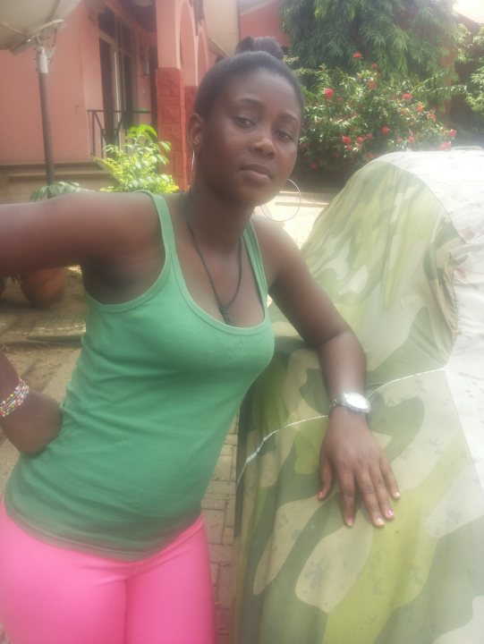 A woman in a blue shirt holding a pink umbrella