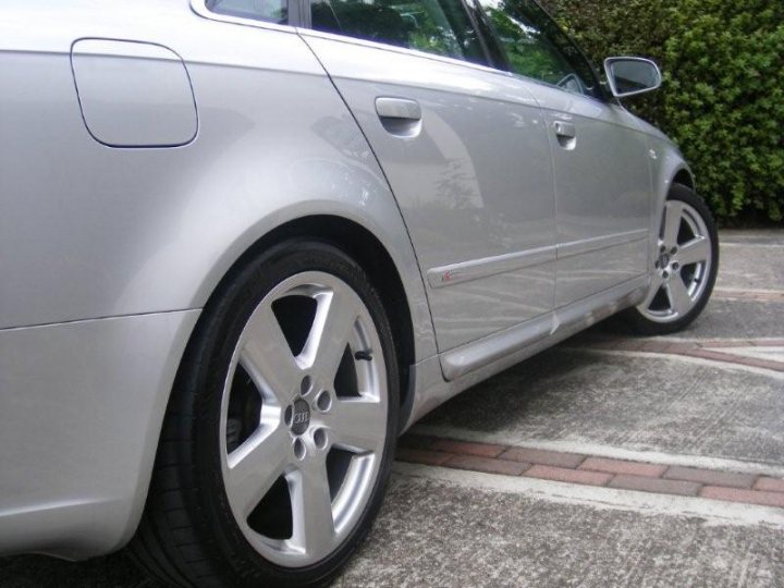 Ireland Sline Pistonheads Tdi - The image showcases the front right side of a silver sedan. The car is parked on a brick-paved driveway adjacent to lush green shrubbery. You can observe the front wheel and part of the front bumper. On the license plate area, there is a dealership logo, suggesting this car might be new or recently purchased. The overall scene suggests a peaceful suburban setting.