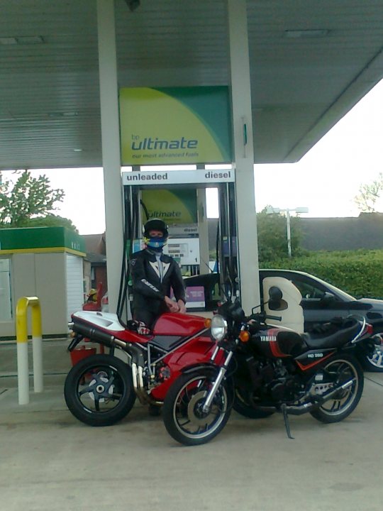 A man standing next to a parked motorcycle - Pistonheads