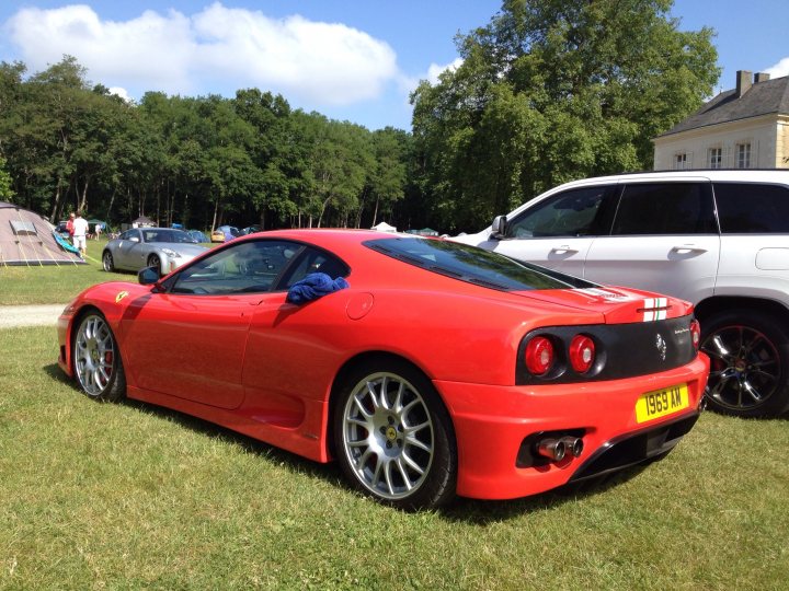 what's your favourite 'rear'? - Page 3 - Ferrari Classics - PistonHeads - In the image, a vibrant red Ferrari sports car is parked on a grassy area. The car is positioned in front of a white SUV, indicating a casual gathering or event. The vehicle's luxury and sporty features, from its sleek lines to the iconic Ferrari logo, are evident. The sunny day and lush green background add a serene backdrop to the vehicles, creating a picturesque scene.