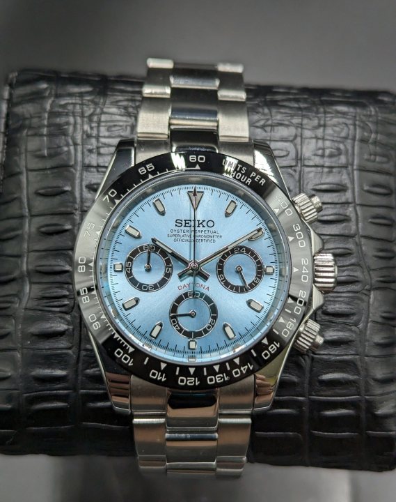 Pistonheads - The image shows a wristwatch with a blue dial and multiple subdials. The watch has a stainless steel case with a silver bracelet, and its face features the brand name 'Seiko' at 12 o'clock. It is displayed against a contrasting background, which includes a crocodile skin pattern. There are no visible texts or additional context in the image that would provide further information about the watch's model or origin. The style of the photograph appears to be a product showcase with a focus on presenting the watch clearly and professionally.