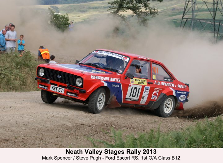 Interesting creations from your mancave - Page 1 - Porsche General - PistonHeads - The image captures an exciting moment in a motorsport field, where a red rally car, emblazoned with the number 101, is driving through a cloud of dust. The car, bearing the Ford Escort RS mark, is in motion, heading towards the left side of the image. The scene is witnessed by spectators standing on a hill to the left, their figures small against the backdrop of the moment. The year '2013' is indicated, and the location is given as Oslo's Class B. This event appears to be a stage of the 2013 Neath Valley Stages Rally, a festive and exhilarating show of speed and competition.