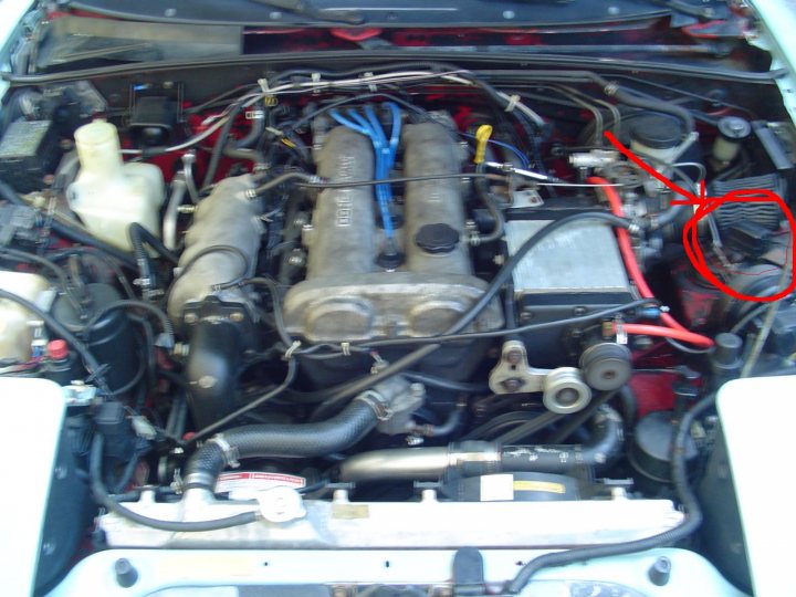 Pistonheads - This image showcases the engine bay of a vehicle, with a particular focus on the engine components. Various hoses and tubes are visible, connecting different parts of the engine. Some tools and parts are scattered around, possibly indicating some maintenance or repair work in progress. There's also a red spray can near the top-right corner of the image, which might have been used recently. One interesting detail is a white bottle with a black lid, placed on the left side of the engine bay. Despite these indications of ongoing work, the exact nature of the maintenance or repair is not discernible from this image alone. The image does not provide any textual information or context.