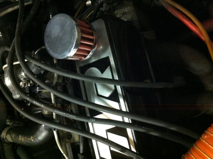 A man standing in front of a kitchen counter - Pistonheads - This image provides a close-up view of the underside of an automobile engine. The primary focus is a grey electric generator submerged in engine oil, with visible wires and black and white branding. The surrounding metallic parts of the vehicle's engine bay are partially visible, emphasizing the complexity of internal automotive hardware. There's an unusual roll of electric tape at the bottom, coiled and ready for use. The colors in the image are dominated by grey, white, and black, with a touch of orange from the wooden dowel visible at the bottom. This image seems to be a reflection on the inner workings of a motor vehicle.