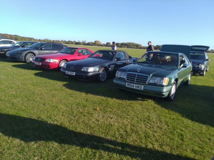A couple of cars are parked in a field - Pistonheads