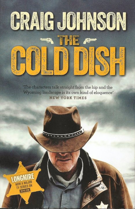 Books - What are you reading? - Page 406 - Books and Literature - PistonHeads UK - The image is of a book cover. It features a man in the center, wearing a cowboy hat and standing with one hand on his hip. He has a rugged appearance and is looking slightly to the side with a serious expression. The background is a dark sky, suggesting an evening or night setting.

The book's title, "The Cold Dish," is prominently displayed in large white letters at the top of the cover. Below it, the author's name, "Craig Johnson," is written in smaller white lettering. The bottom right corner has additional text that reads "Longmire" and "Walt Longmire."

The book cover also contains an image of a gun, reinforcing the western or law enforcement theme suggested by the man's attire and the title. The overall style of the image is realistic with attention to detail, typical for a book cover designed to attract potential readers interested in crime, thriller, or western genres.