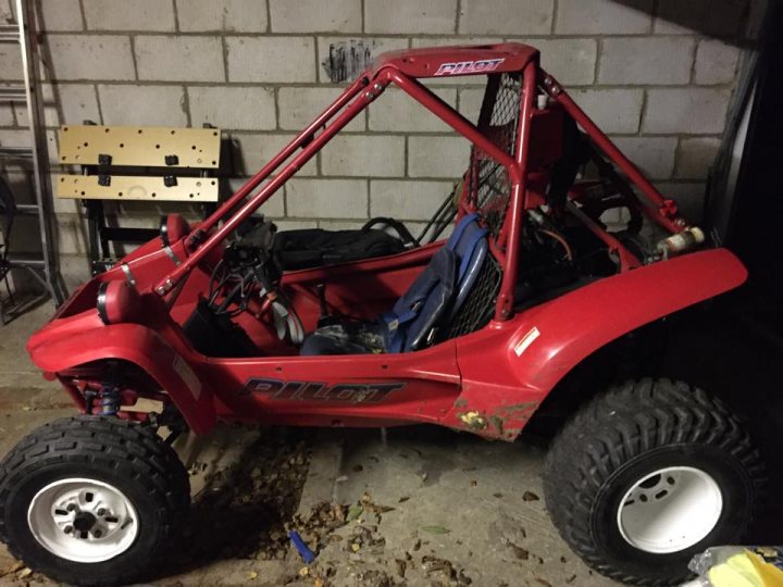 A red motorcycle parked in a parking lot - Pistonheads - The image depicts a vibrant red all-terrain vehicle (ATV) parked indoors, specifically in a garage. The ATV is stationary, with its four-wheel drive ready for off-road adventures. Inside the vehicle, there is a backpack, possibly filled with essential items for an outdoor journey. The ATV is parked next to a brick wall, which serves as a backdrop for the vehicle. From the perspective of the photo, the ATV consumes a significant portion of the image, emphasizing its size and readiness for action.