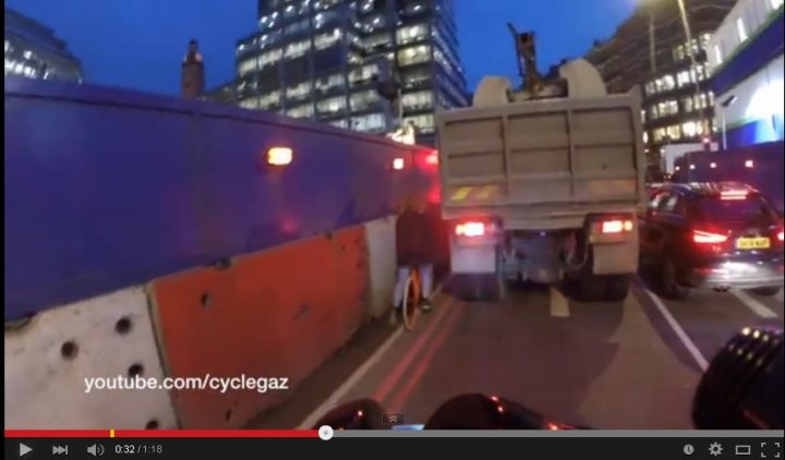 A large truck driving down a street next to tall buildings - Pistonheads