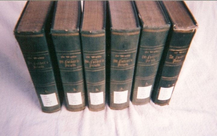 The image shows a collection of books arranged in a linear format, possibly on a white surface. Each book appears to be a hardcover volume with a prominent spine. The spines of the books are uniformly colored, suggesting that they are part of a series. The books are oriented in the same direction and are aligned closely together, indicating that they may be organized by size, title, or some other systematic category. The style of the image is reminiscent of a traditional book display, with the books presented in a repetitive fashion that is common for historical or academic collections.