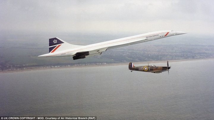 Post amazingly cool pictures of aircraft (Volume 2) - Page 202 - Boats, Planes & Trains - PistonHeads - The image depicts a captivating aerial view featuring two airplanes capturing the essence of aviation history. Above the scene, a red, white, and blue Concorde SST, known as the Union Jack, glides effortlessly, its sleek form cutting through the sky. Below it, soaring towards the horizon, is a vintage, camouflage-painted military aircraft, a testament to the bygone era of World War II aviation. Both aircraft are silhouetted against the backdrop of the sky, creating a striking contrast with the vast expanse of the ocean below. The perspective is slightly above and to the side of the Concorde, providing a unique vantage point from which to witness this fascinating encounter between past and present.