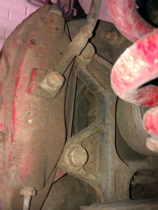 Pistonheads - The image shows the close-up of a mechanical part that appears to be the engine block of a vehicle. It appears to be a dirty and rusted component, indicating it might be from an old or poorly maintained vehicle. There are visible bolts and metal fixtures that suggest it's part of a complex assembly. The overall condition of the part suggests it might need repair or replacement.