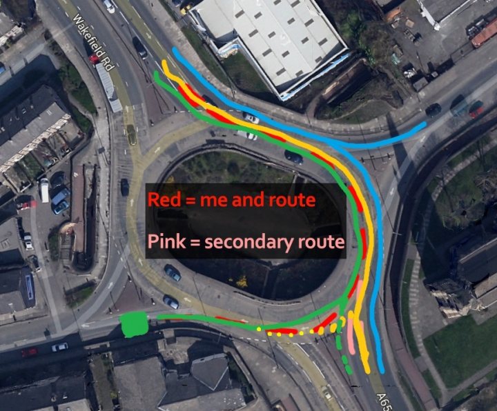 New driver, having issues with roundabouts. Any help? - Page 1 - Advanced Driving - PistonHeads - The image is a composite of an aerial city map and a colorful, digital overlay. On the map below, there is a visual representation of a highway interchange with various colored lines and segments on top of the cityscape. The overlay appears to illustrate potential routes or pathways, particularly in relation to road design or urban planning. The colors red and blue are prominent, highlighting different segments of the routes. Above this overlay is the caption "Red = me and route Pink == secondary route", which suggests the photo is taken from an airplane, and the labels are self-explanatory, indicating the image maker's travel route through the city.