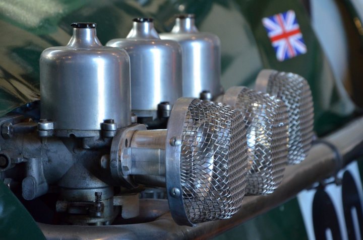 A bunch of pots that are on a table - Pistonheads - This image features the engine of a silver motorcycle with a British Union Jack flag patch. The engine is adorned with a chrome air filter or a decorative grill, and a series of metallic pipes and cylinders beneath it. The photo is taken from a perspective looking up at the motorcycle, showing its engine and decorative elements.