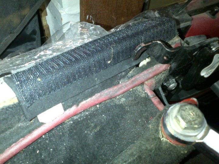 A pair of shoes sitting on top of a wooden bench - Pistonheads - The image showcases a close-up of a workspace, possibly a garage, where a piece of machinery, resembling a pivot point or a part of a mechanical tool, is in focus. Atop this device is a black fabric or mat with a woven texture, suggesting it's used for grip or to prevent damage to the machine. Attached to this pivot or tool is a red cable or pipe, which is connected to a silver metallic component, possibly a connector, to the right. The image gives away a sense of a professional environment and demonstrates some form of mechanic or technological device in use.