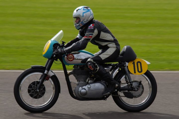 Goodwood Photo Competition - Feb - Page 2 - Goodwood Events - PistonHeads - The image depicts a dynamic scene involving a motorcycle rider. A person is riding a motorcycle with the number 10 prominently displayed on the front, suggesting this might be a racing event or a high-performance ride. The rider is donned in a black and white motorcycle suit, which is typical attire for motorcycle riders due to the safety and comfort it provides during high-speed rides. The motorcycle, which appears to be a racing engine, is positioned on a race track, implying a high-speed activity is about to take place or is currently underway. The rider's choice of gear and the context suggest an exciting blend of speed and skill.