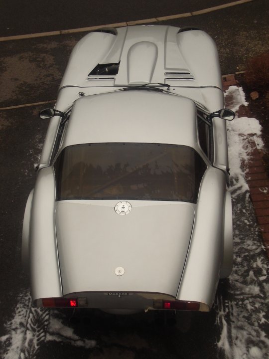 pictures of your car from above... - Page 1 - Readers' Cars - PistonHeads - The image shows the back of a vintage sports car parked outside, possibly on the street. The car is silver in color and appears to be a convertible, given the absence of a roof. The design is sleek and classic, indicative of a vehicle from the 1960s or earlier. The snow-covered ground suggests that the photo was taken during winter.