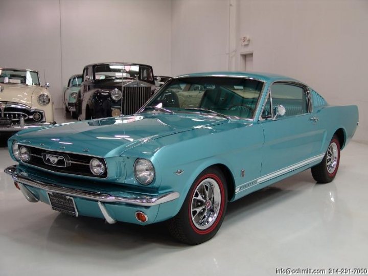 Your restorations  - Page 2 - Classic Cars and Yesterday's Heroes - PistonHeads - The image showcases a striking baby blue vintage Mustang being displayed in a spacious, white-walled garage. The Mustang is positioned in front of another vintage car, suggesting a theme or collection centered around classic automobiles. The white wall backdrop contrasts sharply with the car's vibrant color, emphasizing its vintage appeal. The setting conveys a sense of preservation and appreciation for classic vehicle design.