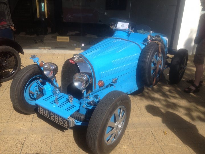 A motorcycle is parked in a parking lot - Pistonheads - The image depicts an antique blue car parked on a brick surface. The car is characterized by its large wheels and a distinctive flat-fronted body. Its blue paint and the gleaming of its vintage details suggest it is in good condition. The car is positioned in such a way that indicates it is ready to be driven. There is a person standing near the car, but they are not the main focus of the image. The setting seems to be an urban area, possibly outside a building or a parking area.