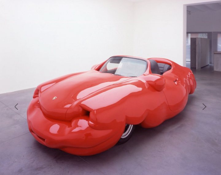 Cars you didn't know existed... - Page 1 - General Gassing - PistonHeads - The image features a bright red, sculptural, lumina bodily car positioned in a modern, garaged space highlighted by a minimalist white wall. The car's unique design is enlarged at the rear, giving it a resemblance to a lumina body or a red sculpture. It's placed on a concrete floor against a white wall, which contrasts against the car's shiny surface, emphasizing its shape and color. The surrounding area is clean and spacious, providing a stark backdrop that makes the car stand out.