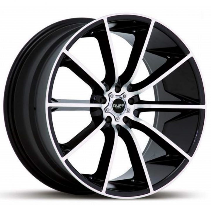 Anyone run 20 inch alloys on a Vantage - Page 1 - Aston Martin - PistonHeads - The image displays an aftermarket tire and wheel set against a plain white background. The wheels are designed with multiple aero-cutting edges, enhancing their aerodynamic and stylistic appeal. The rim color transitions between black and white, creating an appealing contrast. The tire itself appears to be a genuine brand, modern in design, and suitable for high-performance vehicles.