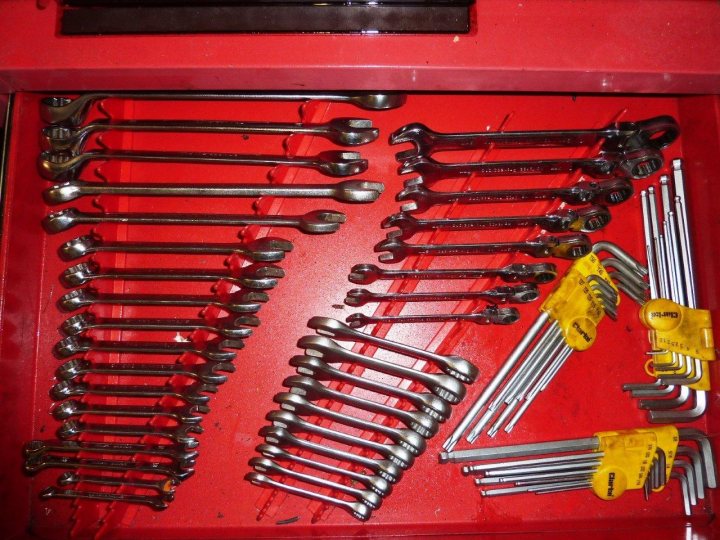 Show us your toolbox! - Page 1 - Home Mechanics - PistonHeads - The image shows a collection of tools, specifically wrenches, neatly arranged within a red drawer. The wrenches are of various sizes and types, indicated by their shapes and the presence of some with yellow handles. The drawer is open, providing a clear view of the tools, and there is another tool on the tool itself, possibly for carrying multiple wrenches. The tools all appear to be made of metal, with the yellow handles suggesting they might be pliers or a similar tool designed for comfort and grip.