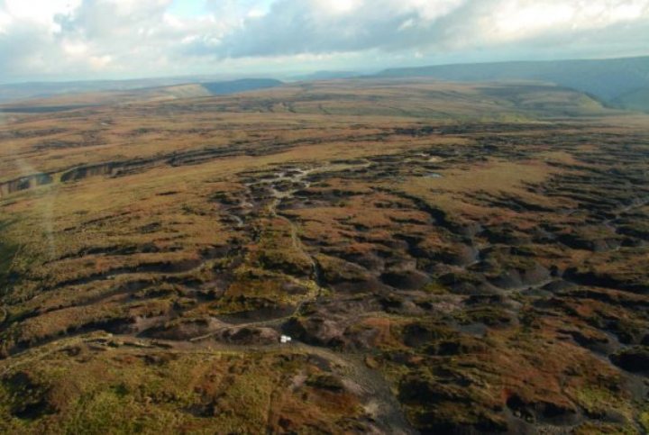 Nursing mother smashes 268-mile Montane Spine Race record - Page 1 - News, Politics & Economics - PistonHeads - The image presents an aerial view of a rural landscape. Dominating the scene are vast stretches of green fields, meticulously demarcated by dirt paths crisscrossing through them. These fields appear to be well-maintained, possibly serving agricultural purposes. In the distance, a small body of water is visible, its surface shimmering under the sunlight. The overall color palette of the image is dominated by various shades of green and brown, reflecting the natural environment captured in this photo. This panoramic view offers a tranquil snapshot of rural life and landscape.