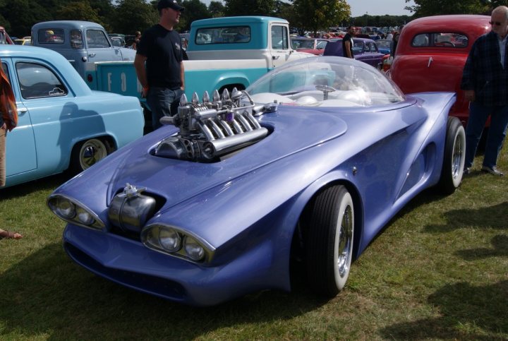 Anyone going to the NASC 40th Nats at Trinity Park? - Page 1 - East Anglia - PistonHeads - The image showcases a vibrant car show. Dominating the scene is a striking blue and silver sports car, its multiple headlights and grille set against a clear sky. The car's glossy finish gleams under the sunlight, catching the attention of the crowd in the background.

In contrast to the sleek sports car, there are a variety of classic trucks in the background. Among them, a bright red truck stands out, its vintage design adding to the diversity of the vehicles on display. 

The crowd in the background is filled with enthusiasm, their focus directed towards the showcased cars. Their expressions and body language suggest admiration and interest, indicating that this is a popular event among car enthusiasts. 

Overall, this image captures the excitement and enthusiasm of a car show, with various makes and models attracting a diverse audience.